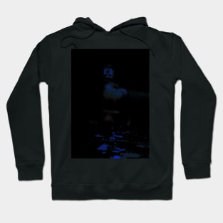 Portrait, digital collage and special processing. Man in dark corner, looking. Blue, glowing eyes. Hoodie